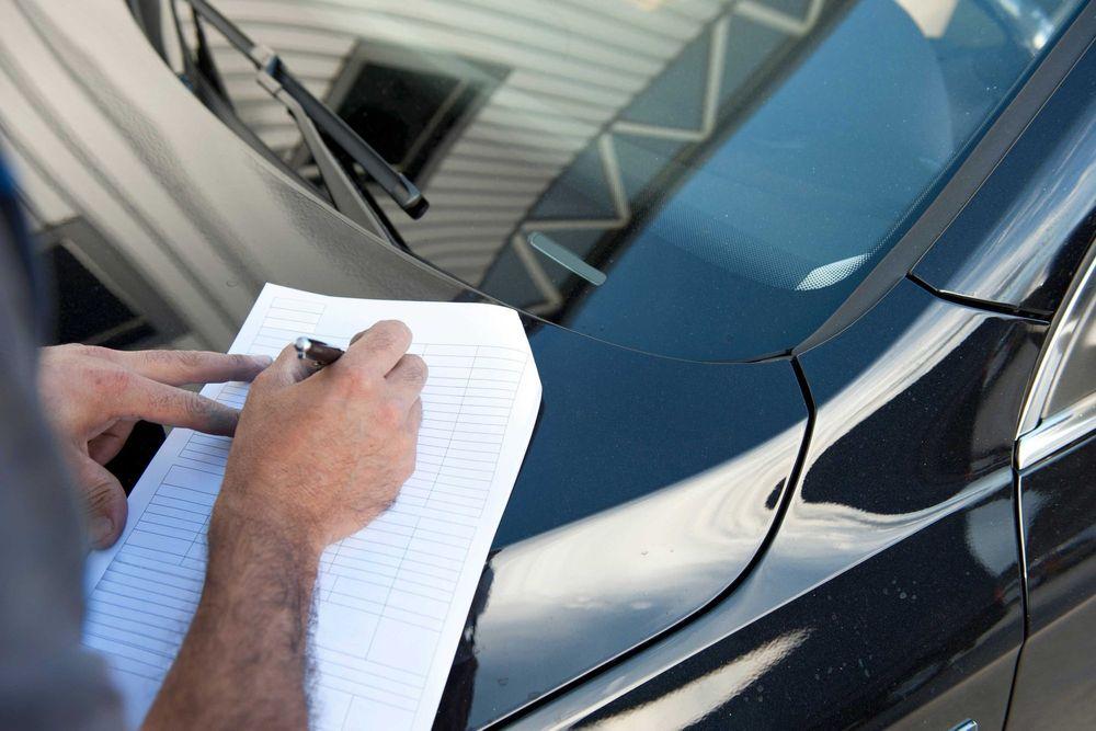 Person performing a vehicle inspection.