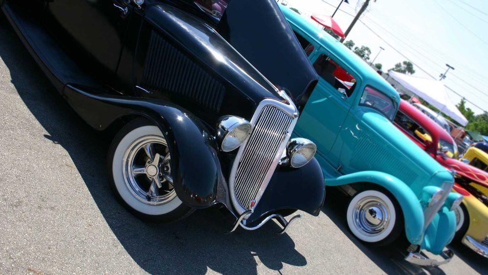 Black and teal Classic cars and Hot rods parked at a car show