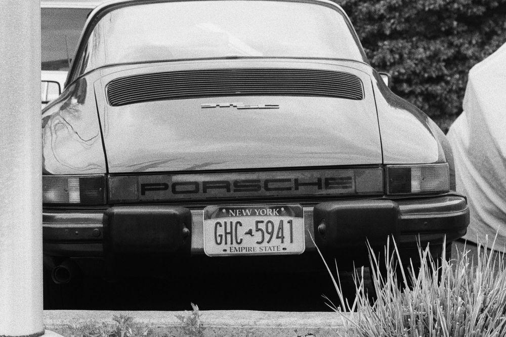 Black and white photo of a Porsche with a New York license plate
