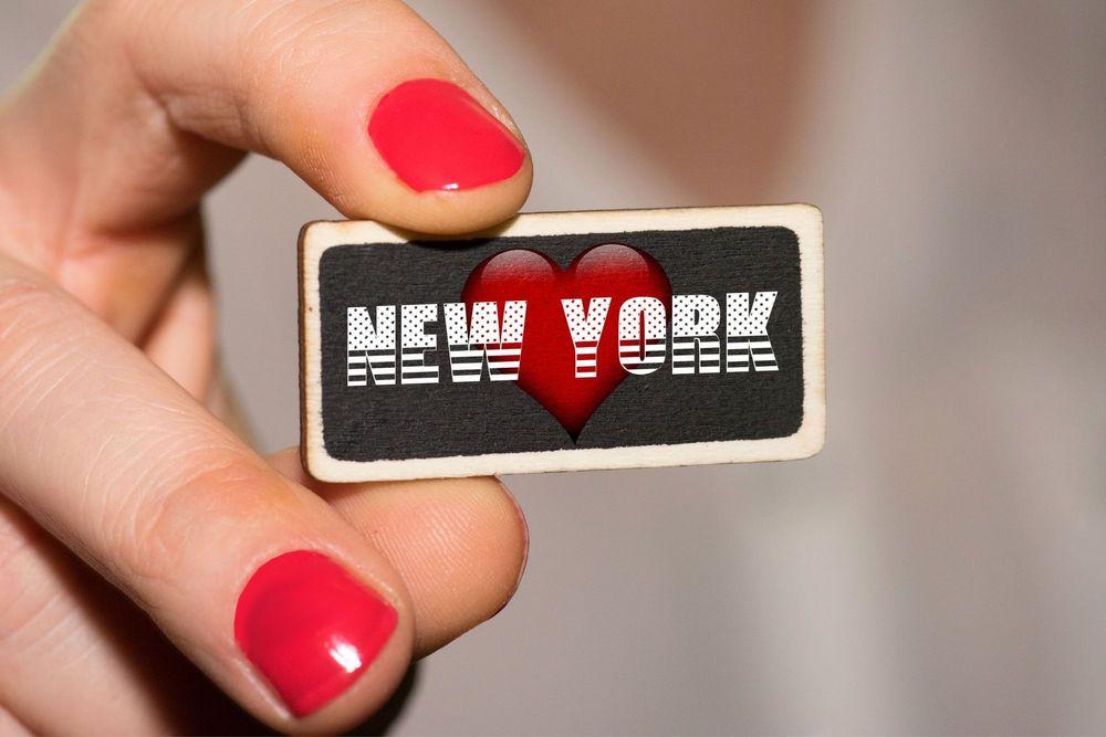 Person holding a piece of metal that says I Love New York