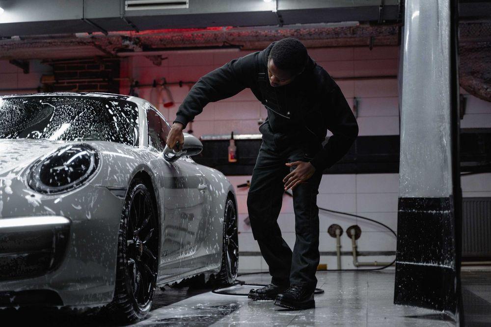 Person cleaning the exterior of their car by hand