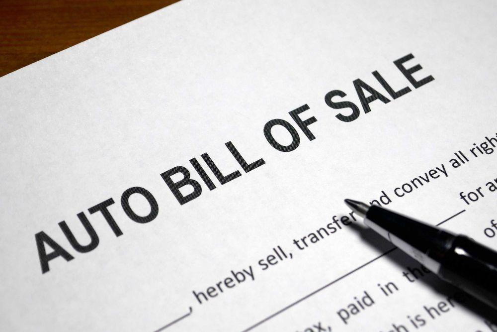 Auto Bill of Sale paper with a pen on it.