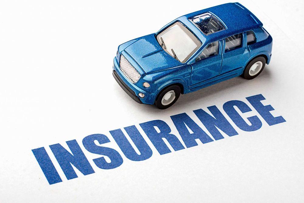 Blue toy car over the word insurance