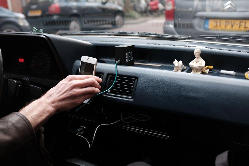 Person hooking up phone to car phone charger.