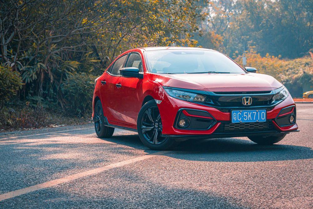 Red Honda Civic parked on asphalt road.