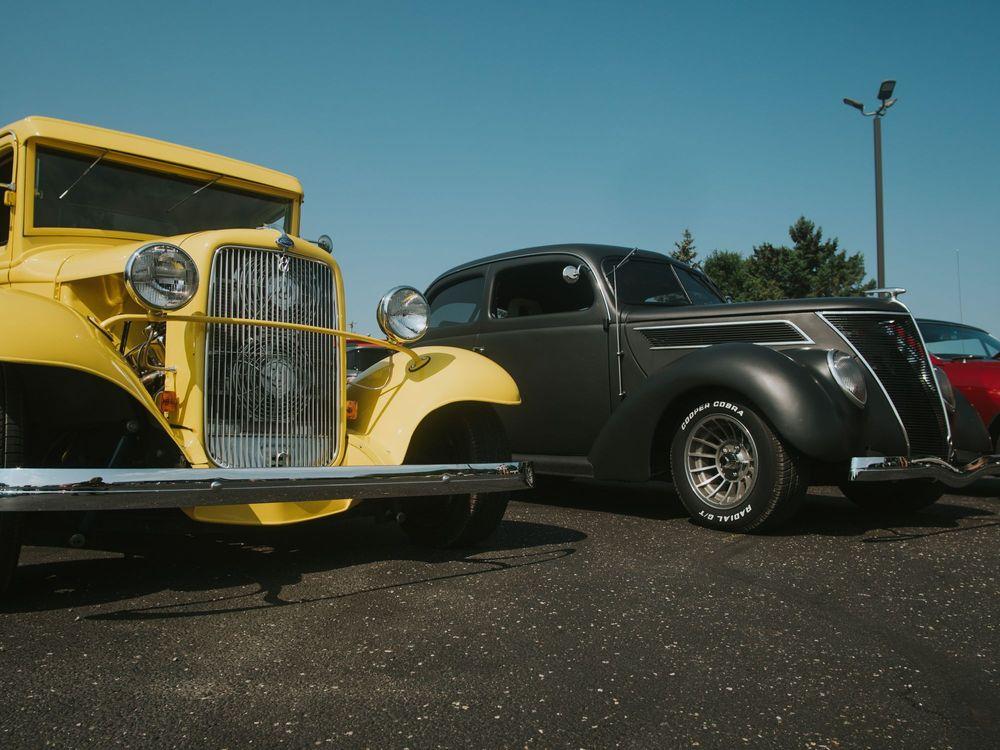 Yellow, Black, and red Vintage Hot Rods parked in a row in a parking lot