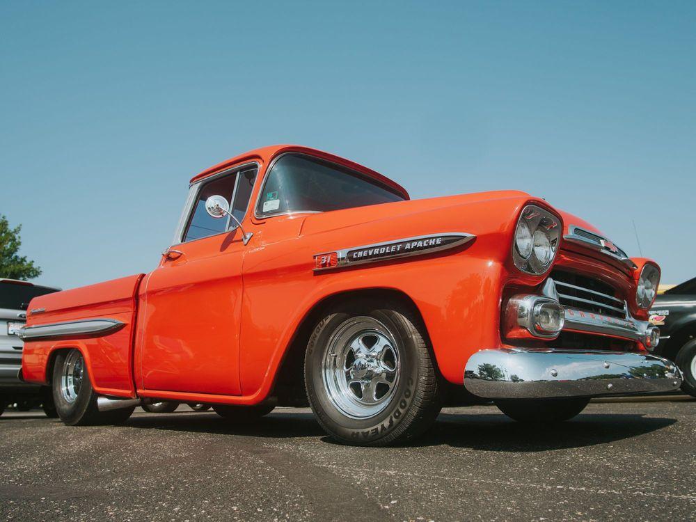 Classic orange Chevy Apache parked in parking lot.