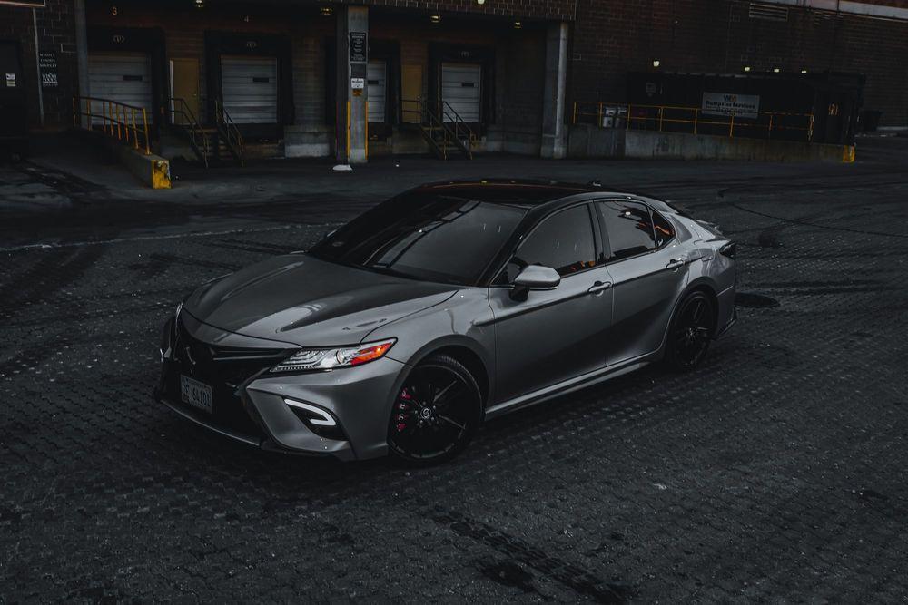 Gray Toyota Camry parked in a dark loading dock.