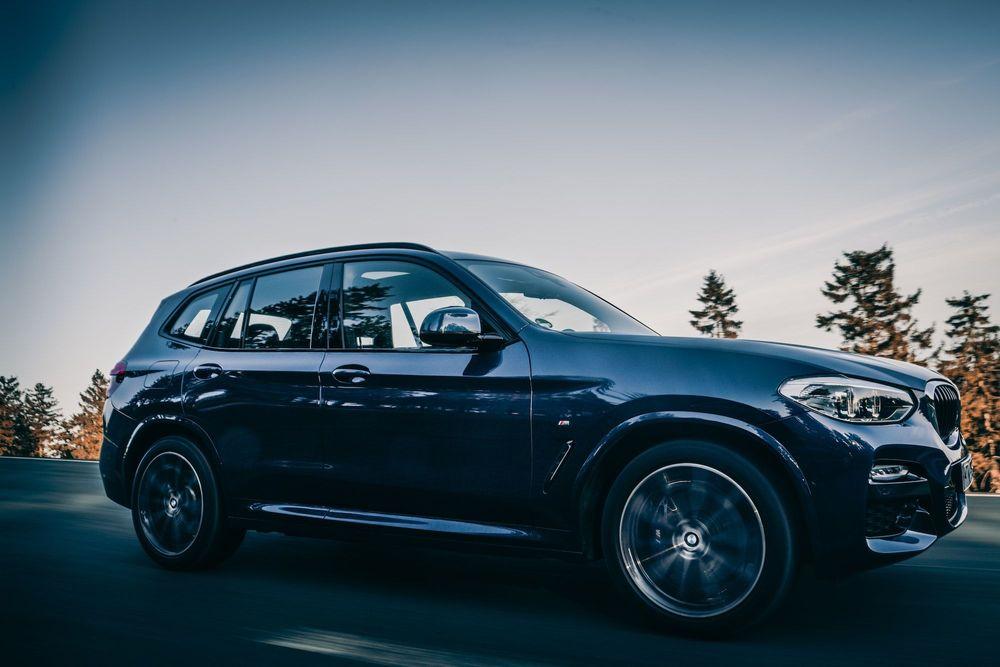 Sedan Car going on a test drive on a road with trees