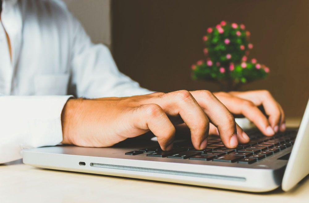 Person at desk using laptop.