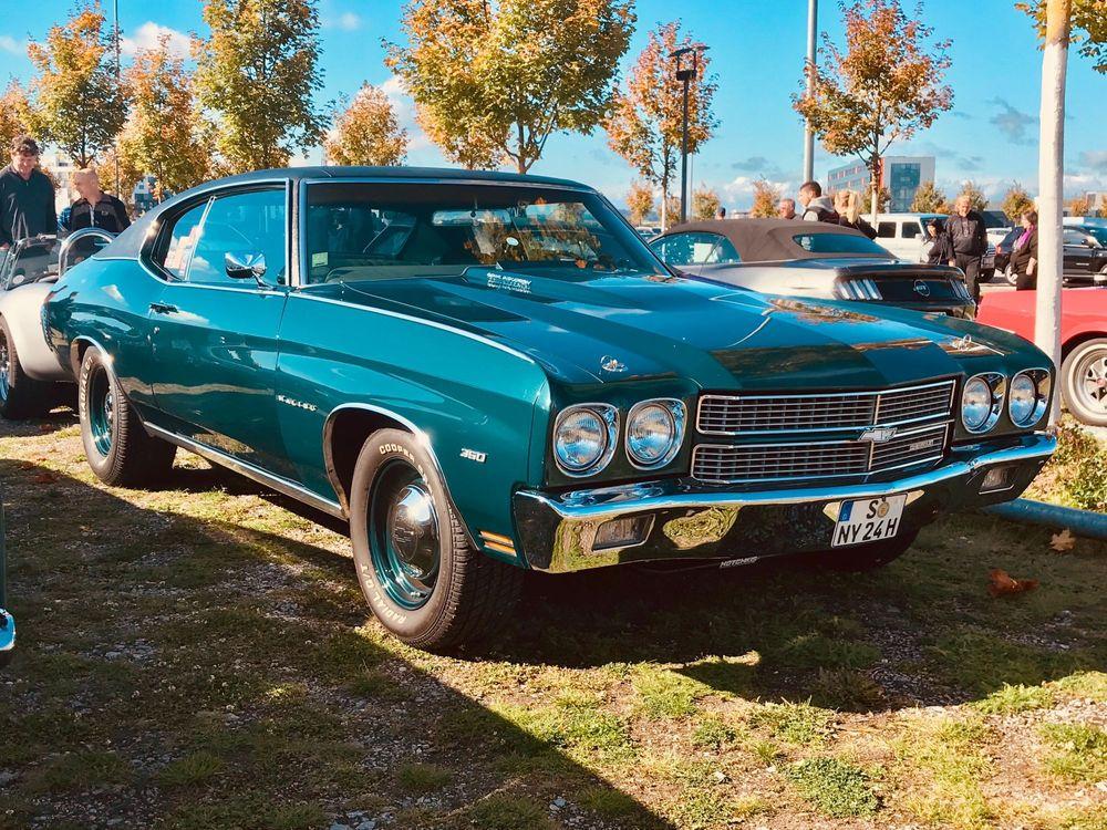 Blue Chevrolet hot rod parked on grass.