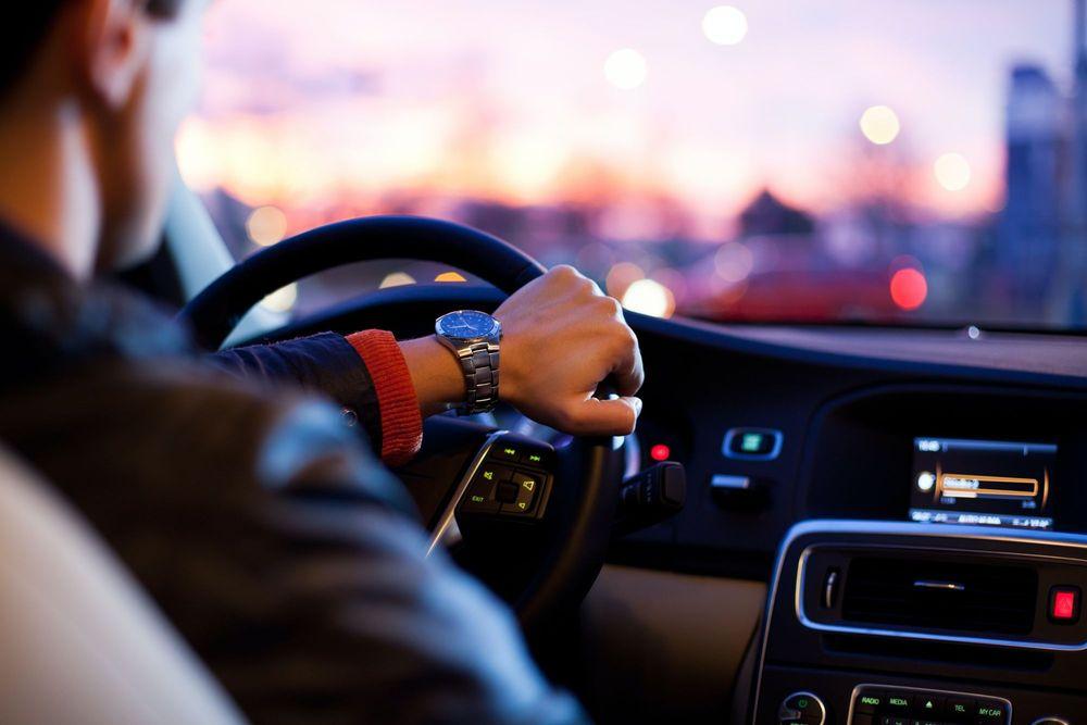 Man with nice watch driving in car.